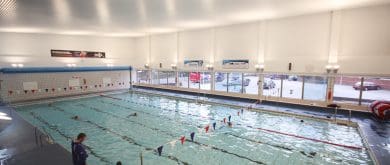 a group of people swimming in an indoor pool